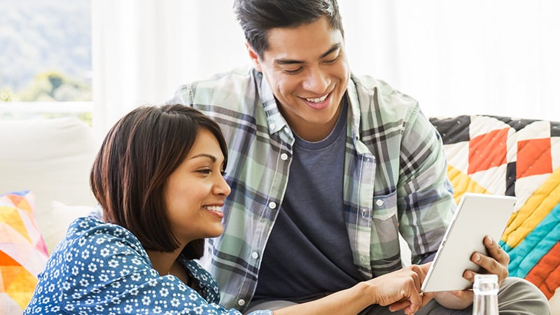 A woman and a man looking at a tablet together.