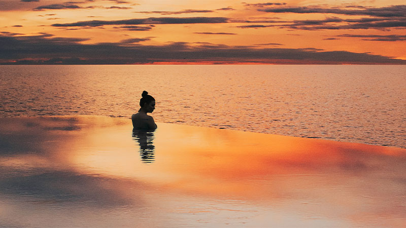 woman in pool at sunset